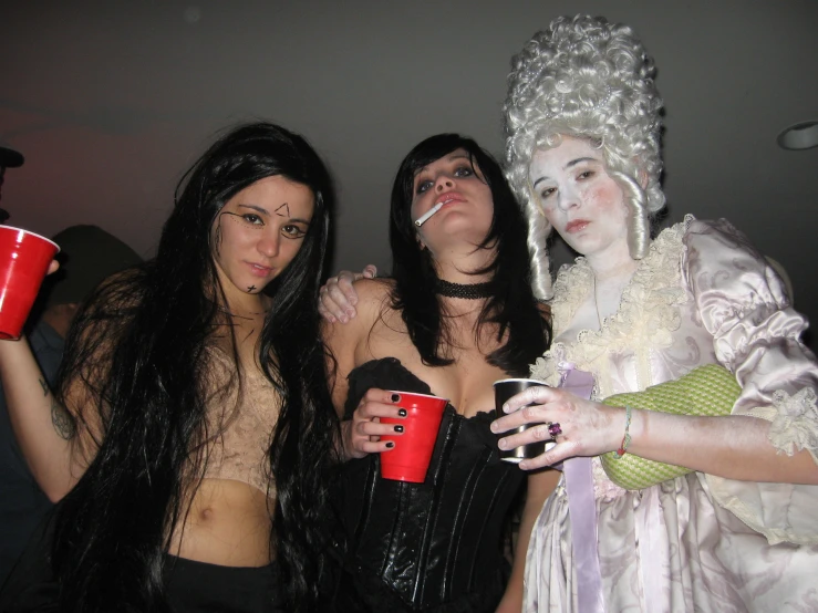 three women dressed up like witches drinking coffee