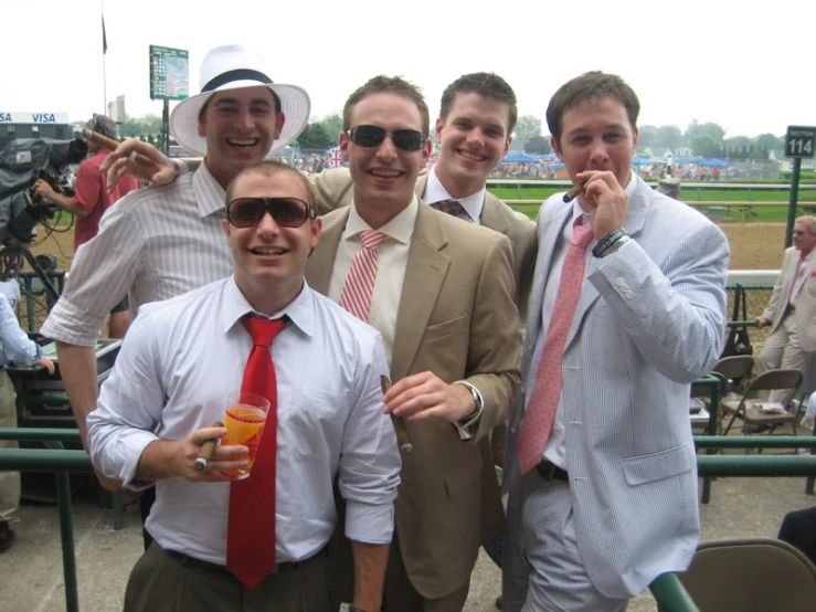 four men in suits and ties pose for a picture