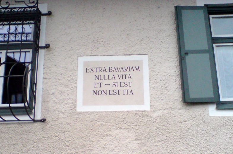 a sign hanging outside a window on the side of a building