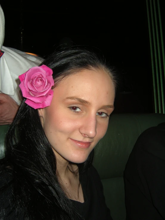 a woman with a pink flower on her hair