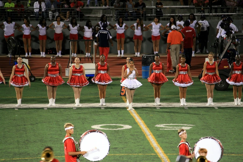 cheerleaders perform during the competition in red dresses