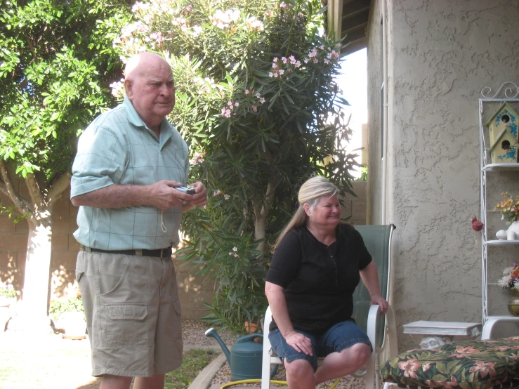 man and woman with cat in backyard area, two of them smiling