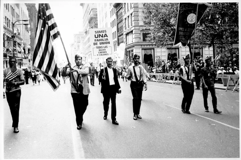 two groups of men walking down the road carrying flags