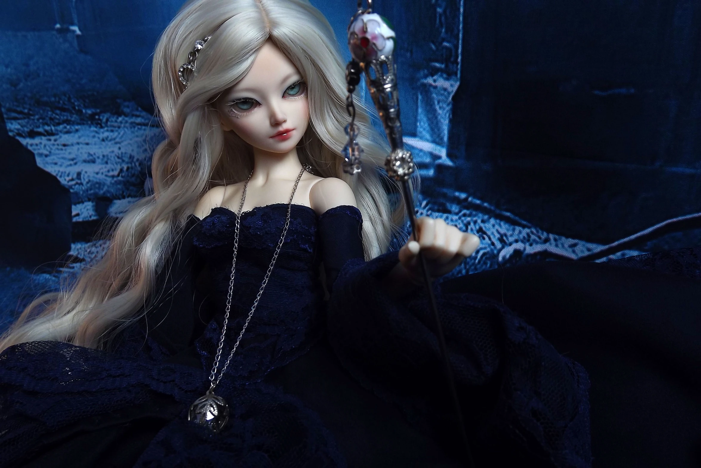 a doll dressed as a fairy with long blonde hair and a sword in her hand