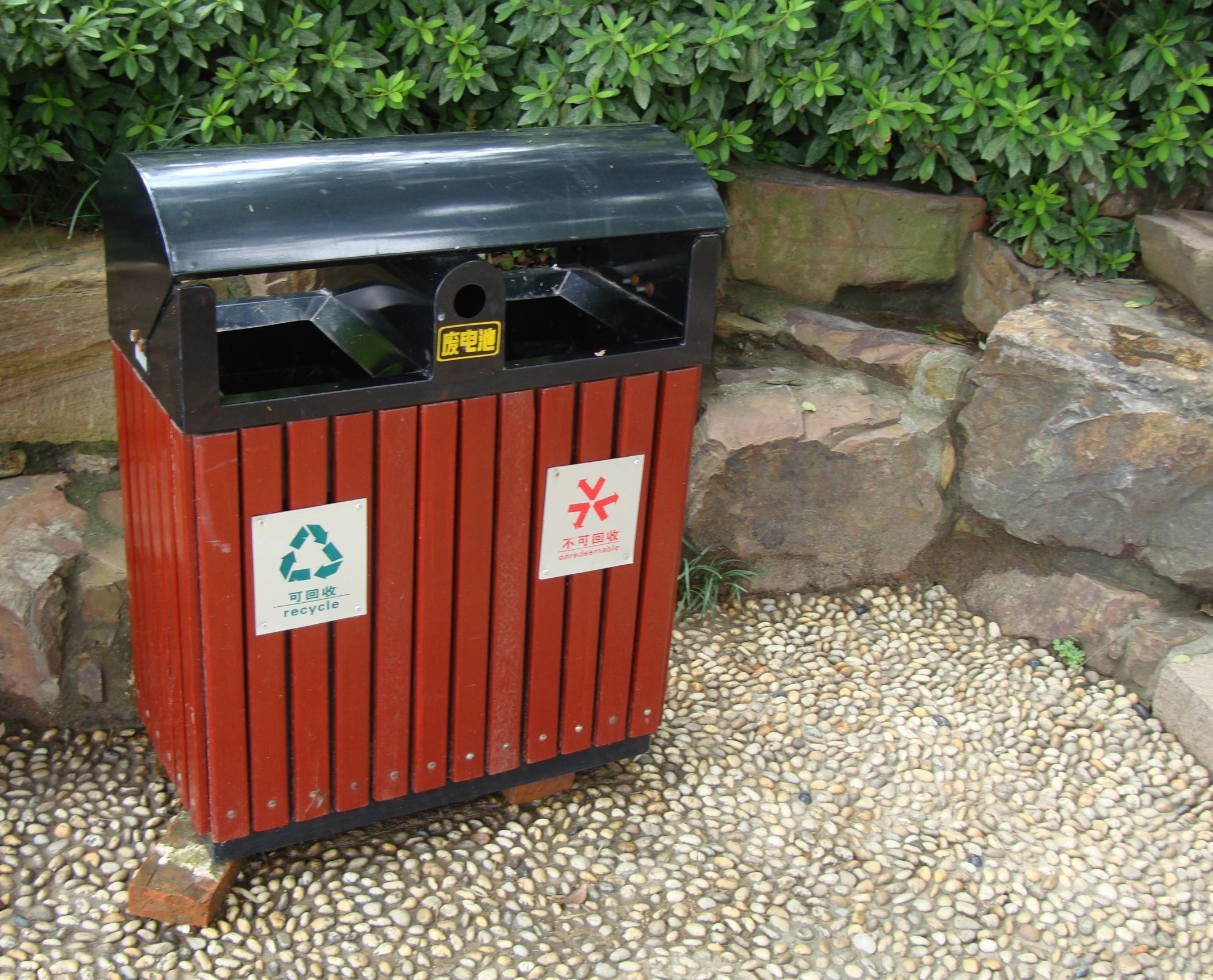 a red trash can with recycling bins on it