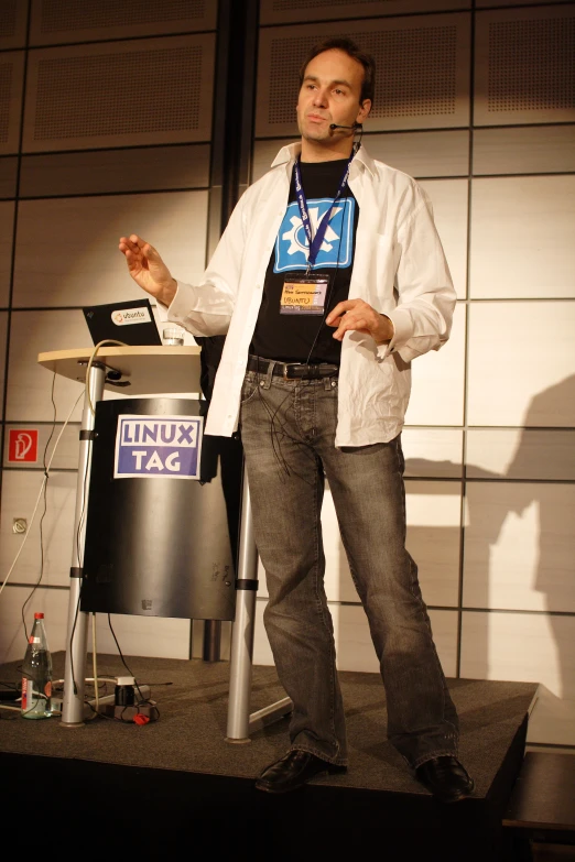 a man is standing with his hands open on a podium