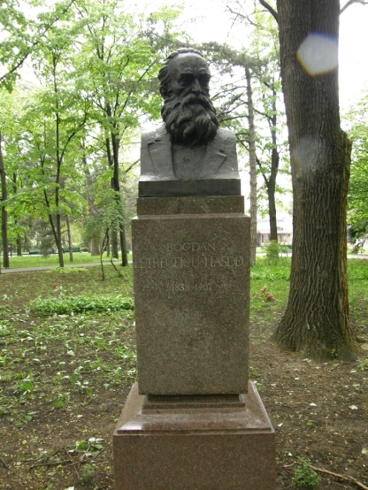 a grave with a large bust in a park