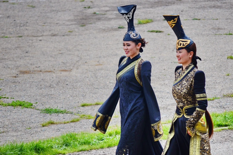 two women wearing fancy hats walking next to each other