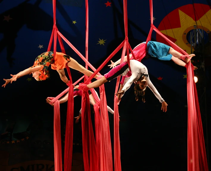 two acrobatic acrobats perform tricks on aerial strings