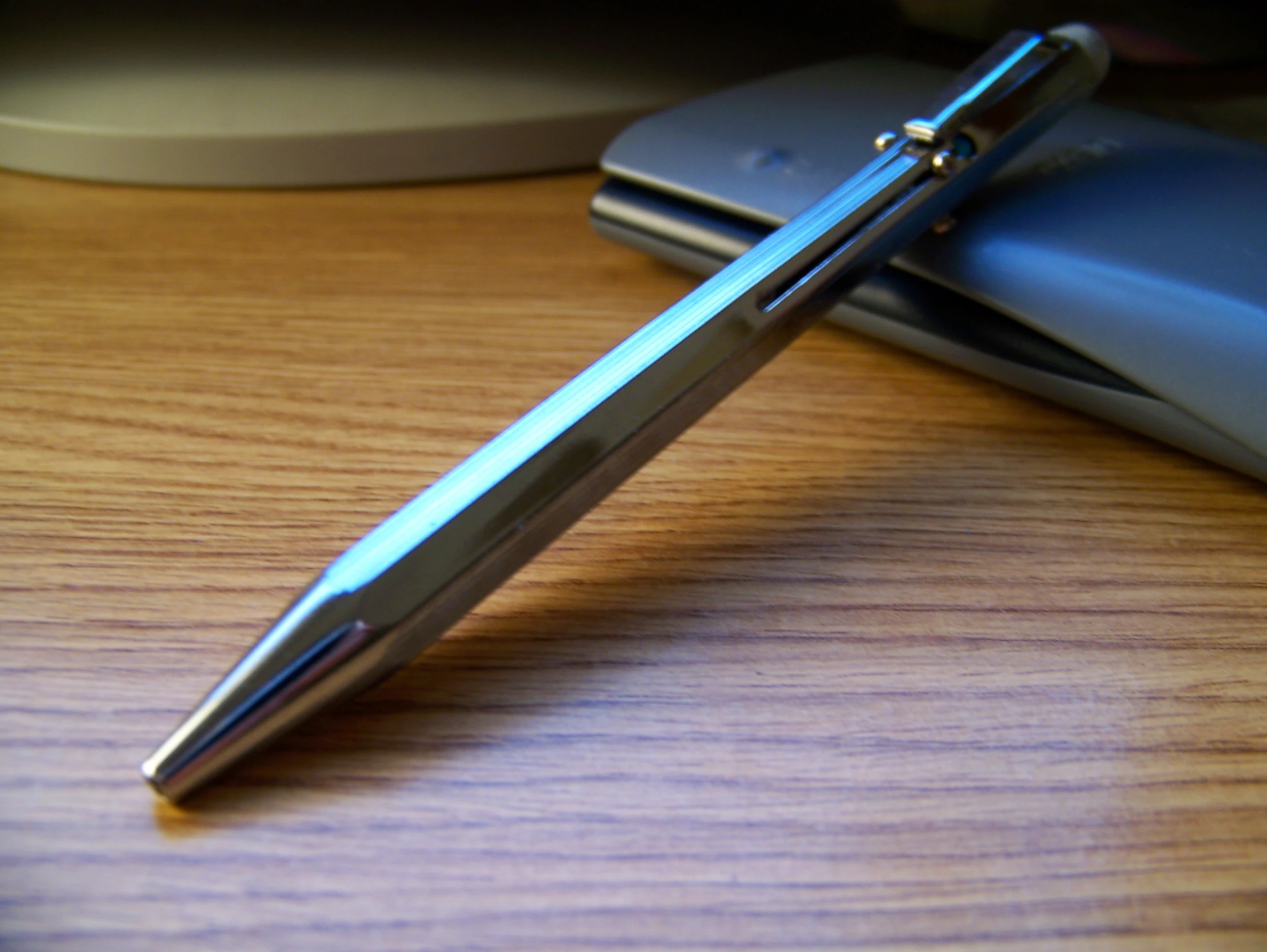 a pen is laying on the table next to a laptop