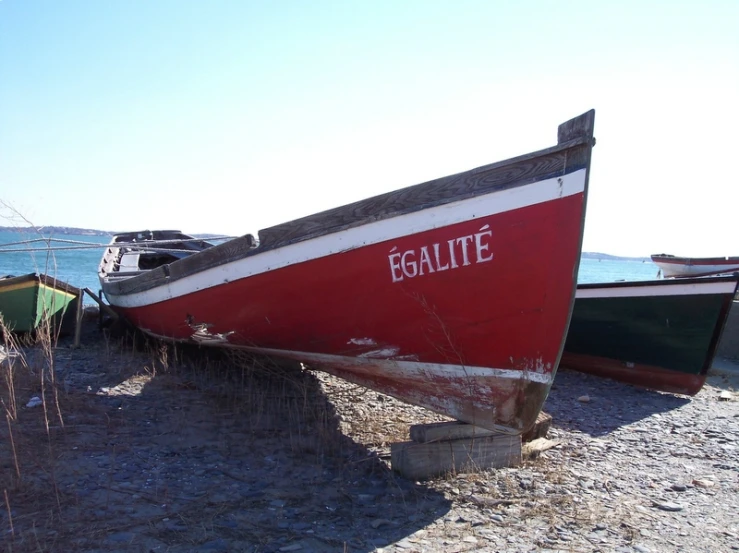 there is an old fishing boat left on the beach