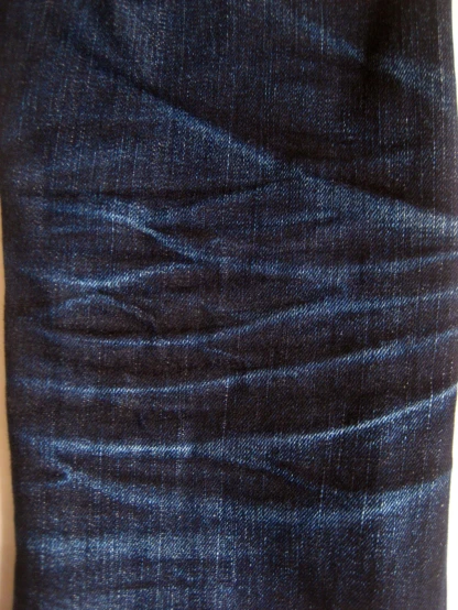 this is the waist of a man wearing a pair of dark blue jeans