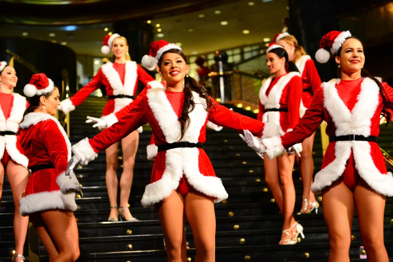 several women in santa clause outfits standing on steps