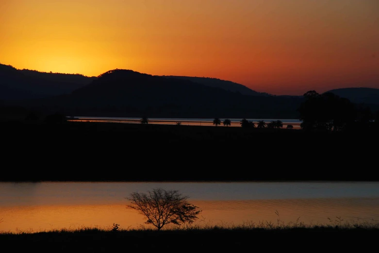 the sun setting behind mountains in the distance