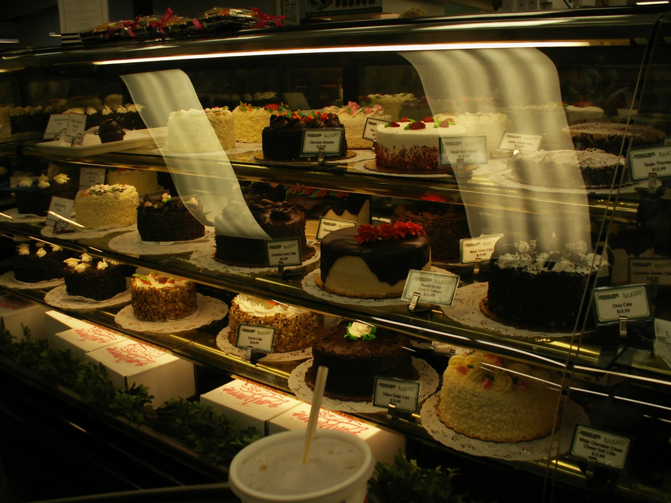 an assortment of desserts sitting in a glass case