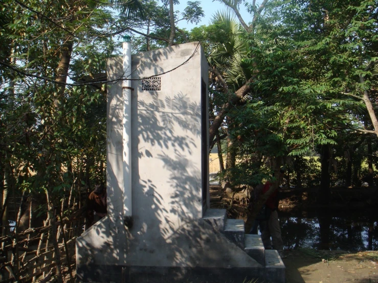 two people stand outside of the monument surrounded by trees