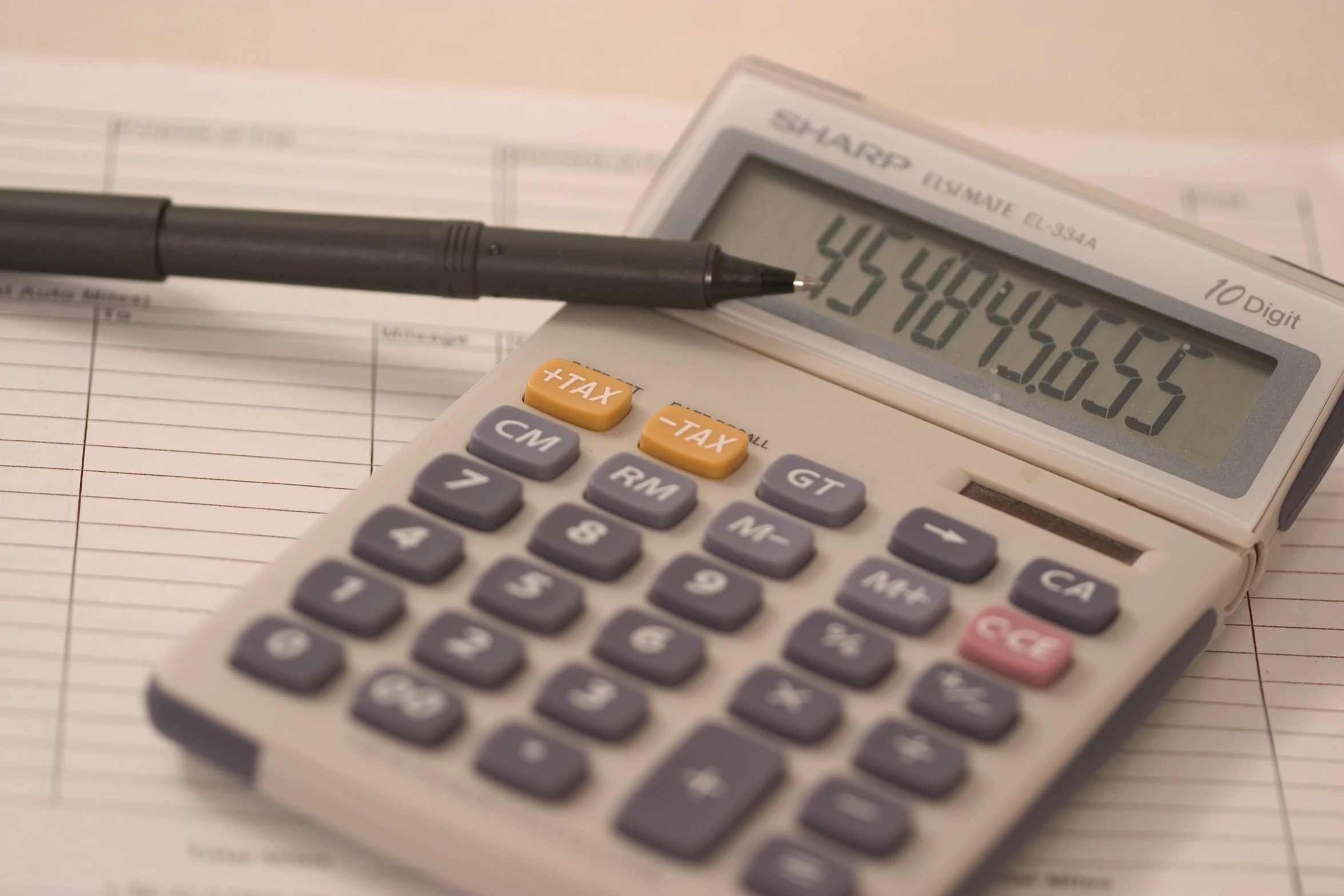 a calculator and pen on a workbook