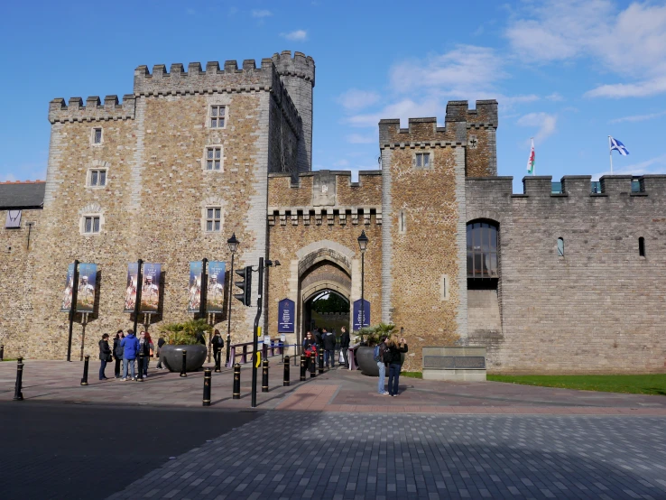 an old castle with flags and people walking