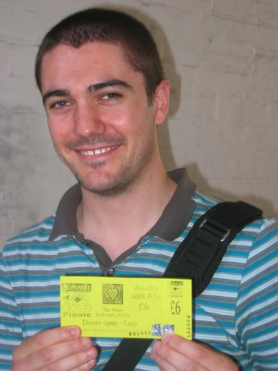 man smiling and holding a yellow and black id badge