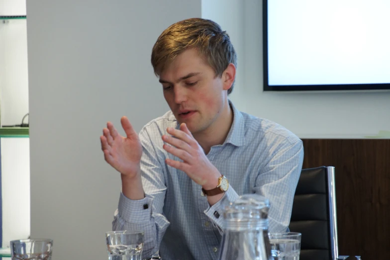 a man in a white shirt holding his hands together