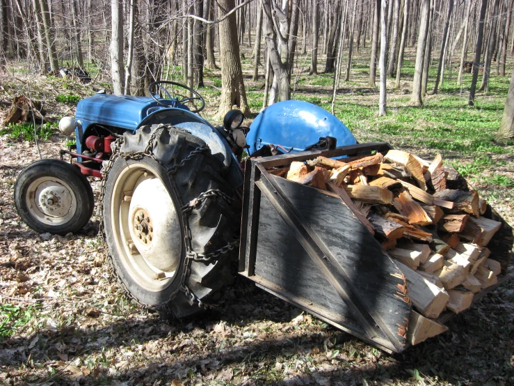 a tractor has been taken out of the woods by a pile of logs