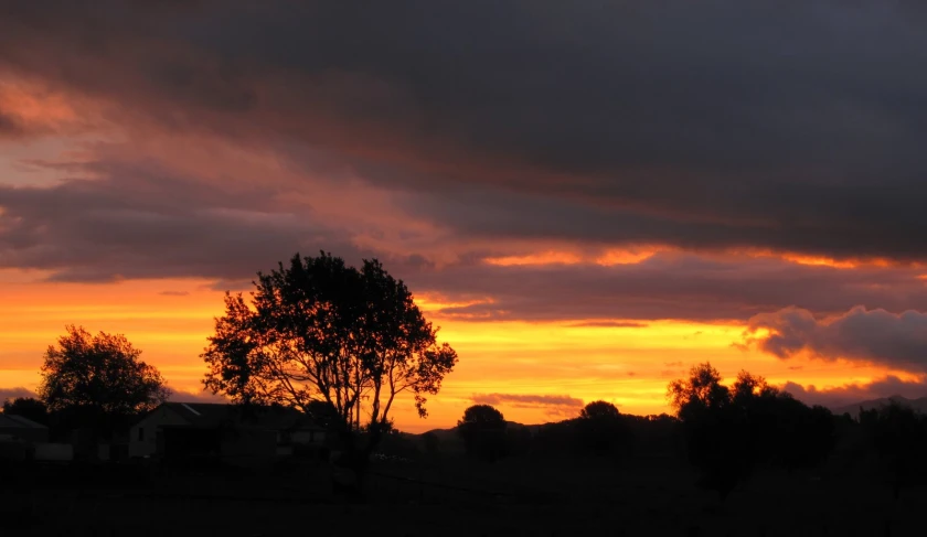 a view of a very beautiful sky over a farm house