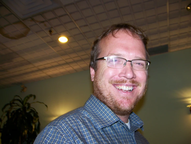 smiling man in glasses wearing glasses and blue shirt