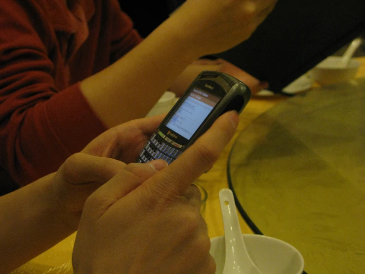 someone is checking out their cell phone on a glass table