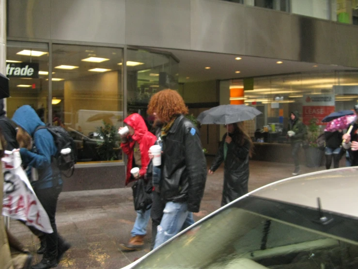 group of people walking down street in rainy weather