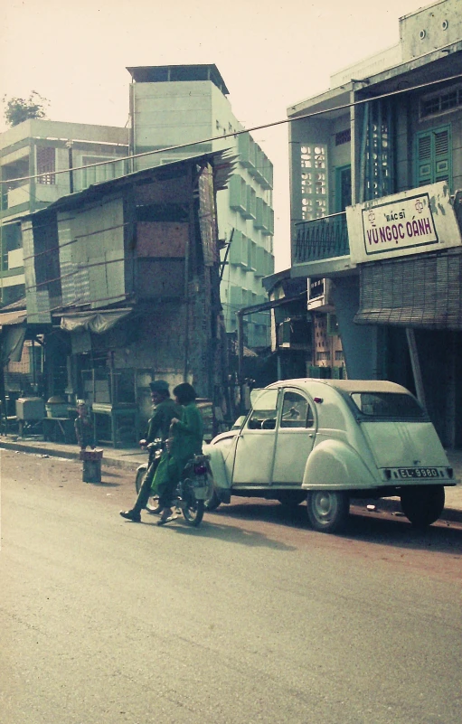 some people sitting on the back of a motor cycle