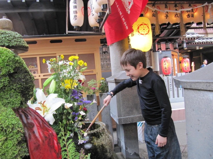 a  cleaning his flowers at a chinese shop