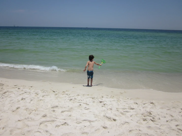 a child on the beach throwing a frisbee