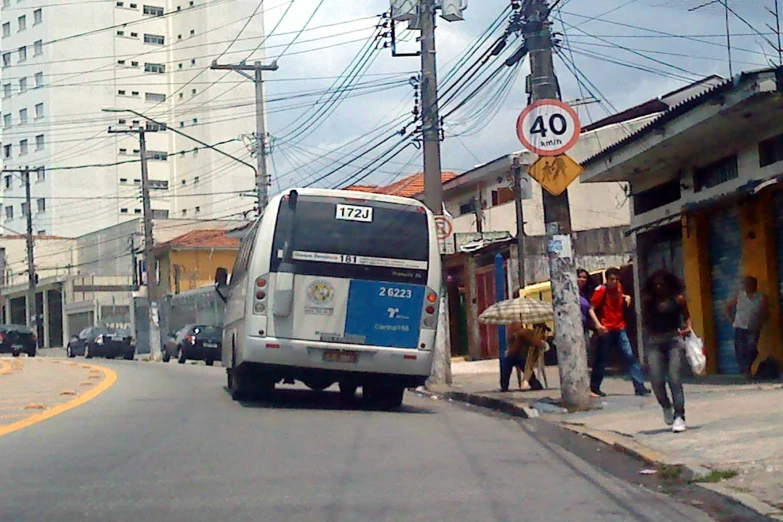 a white bus driving down a road in front of a tall building