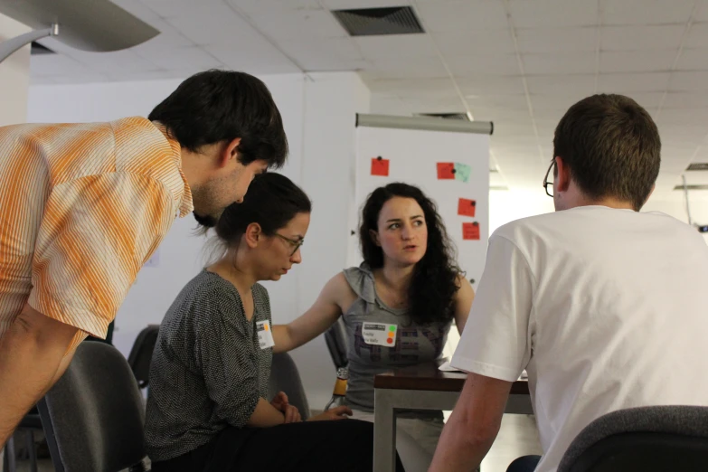 people in a business setting looking at a laptop