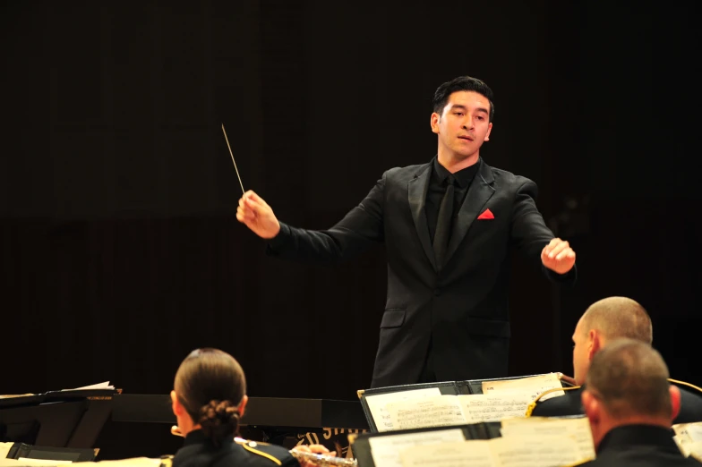 a conductor giving an orchestra performance with his arm in the air
