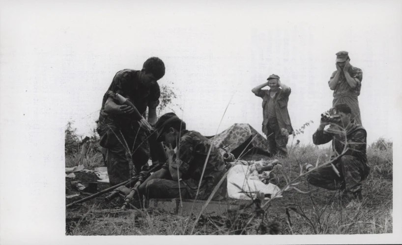 old black and white po of soldiers eating on a dead body