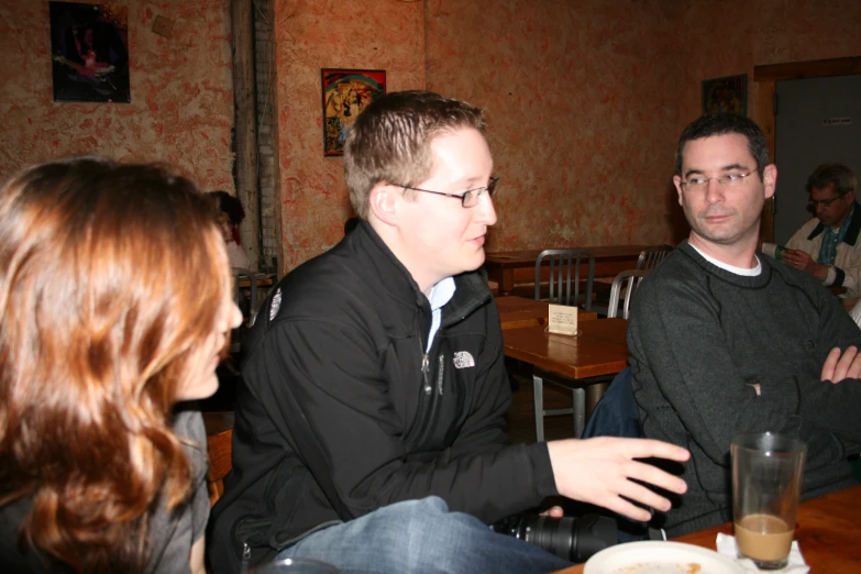 two men and a woman are having conversation in the restaurant