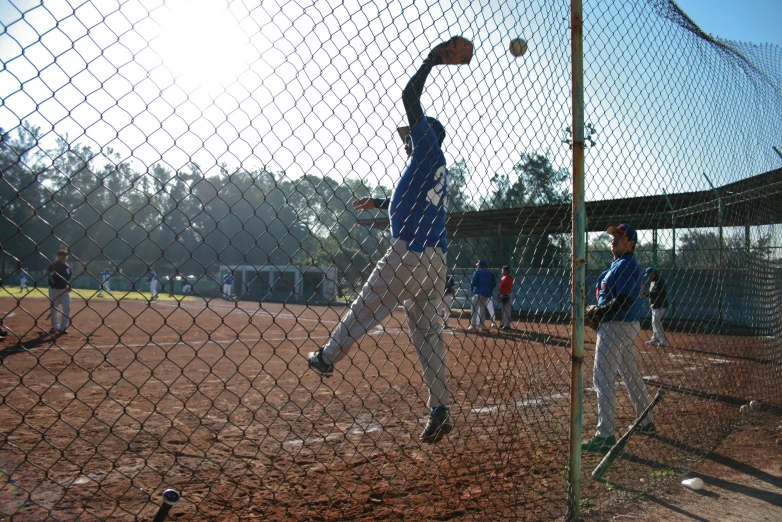 a man that is standing in the dirt with a ball