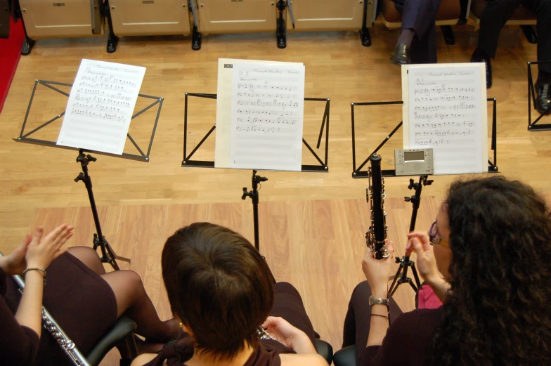 four women sitting on the floor next to musical sheets