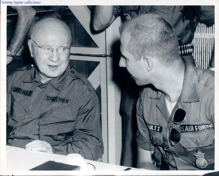 a man signing paperwork to a soldier that is wearing a scout uniform