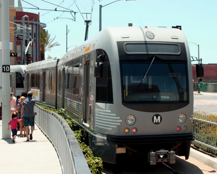 people standing next to a train at a station