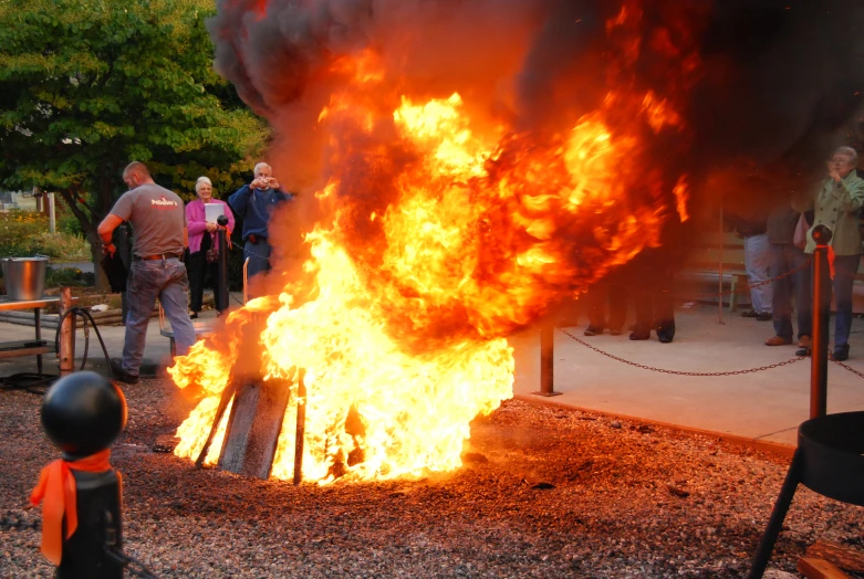 fire burning at an outdoor event next to people