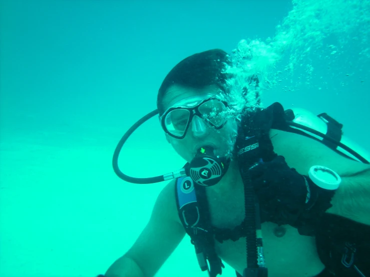 a woman in black wetsuit and goggles diving