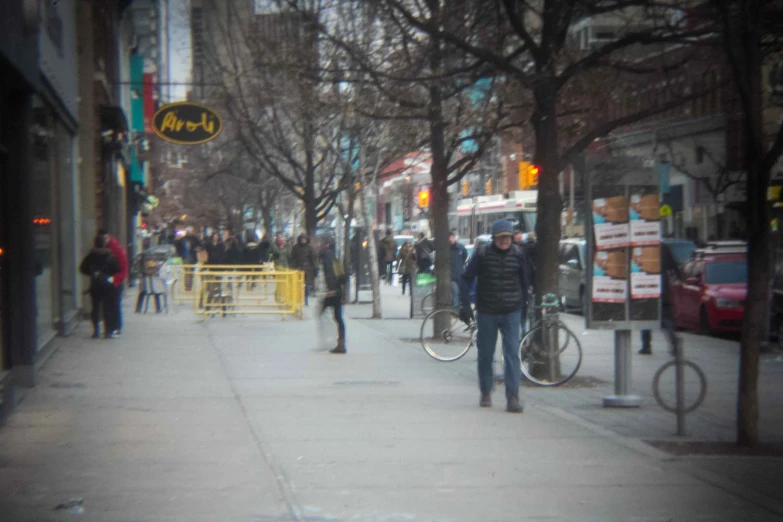 a busy street has people walking down the sidewalk