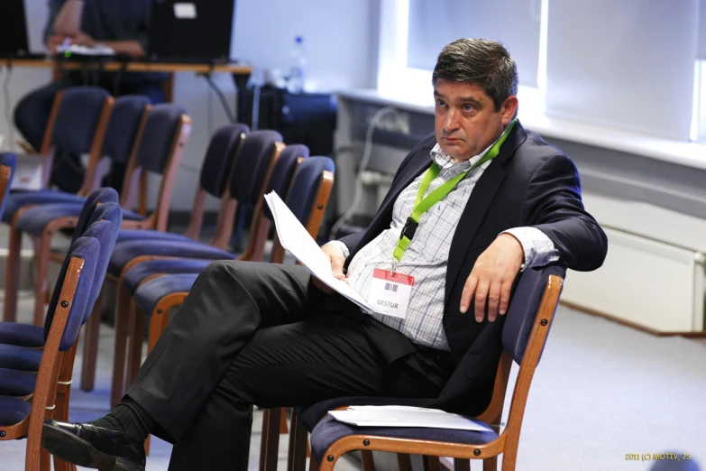 a man sitting in a chair with a book on his lap