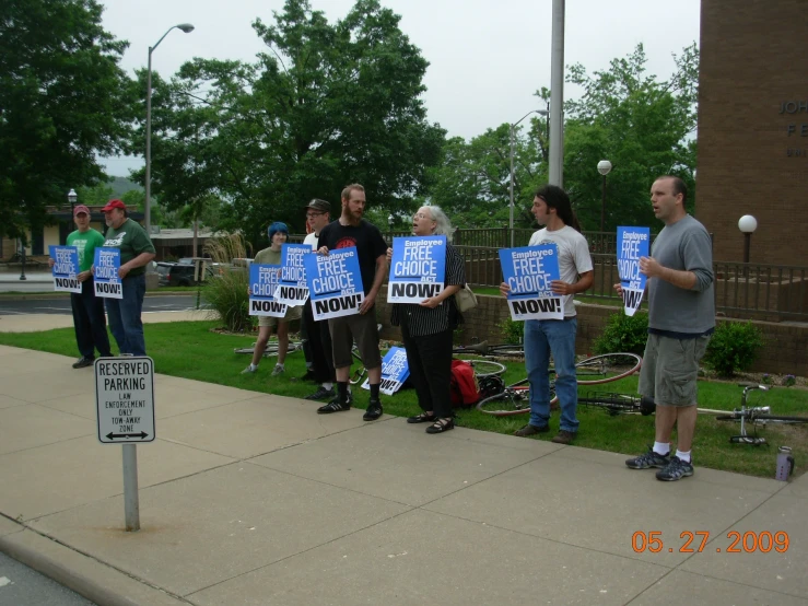 people standing and sitting in a group holding signs