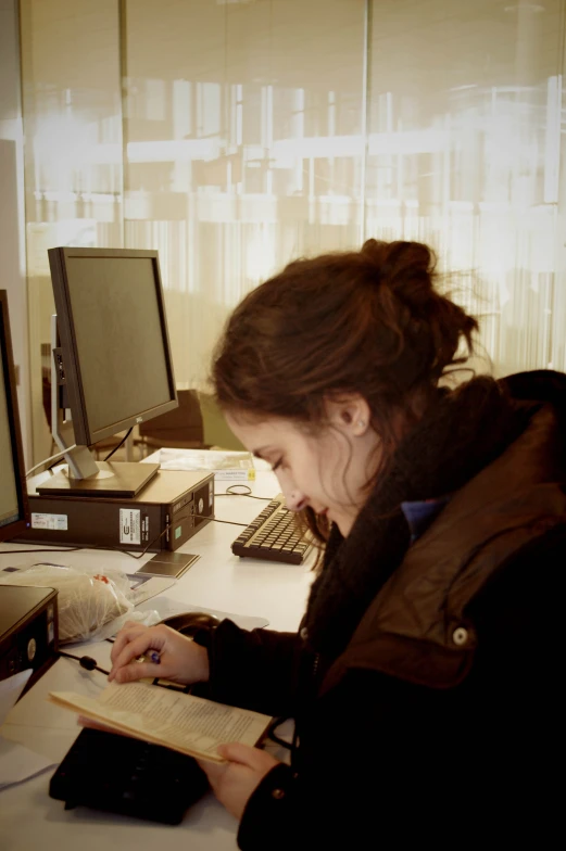 woman sitting at desk working on a book