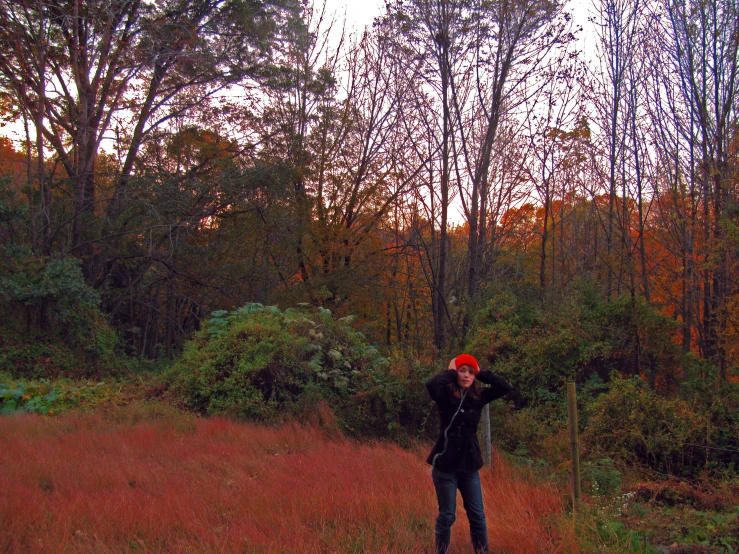 a young person in a field with trees in the background