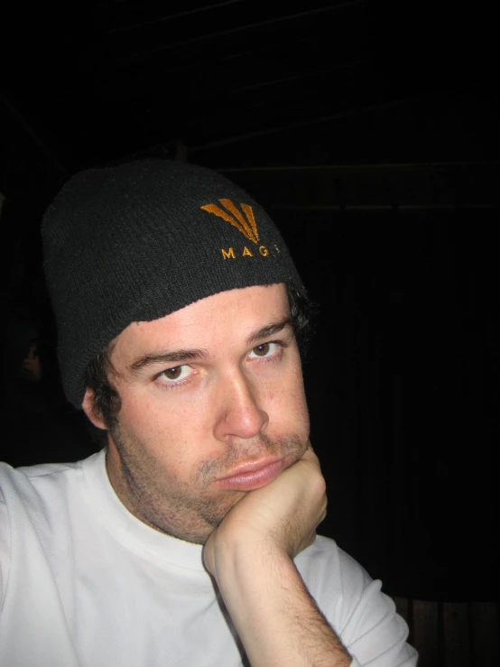 a man is posing for a camera with his arms resting on the wall