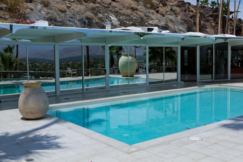 a very large pool sitting by some mountains